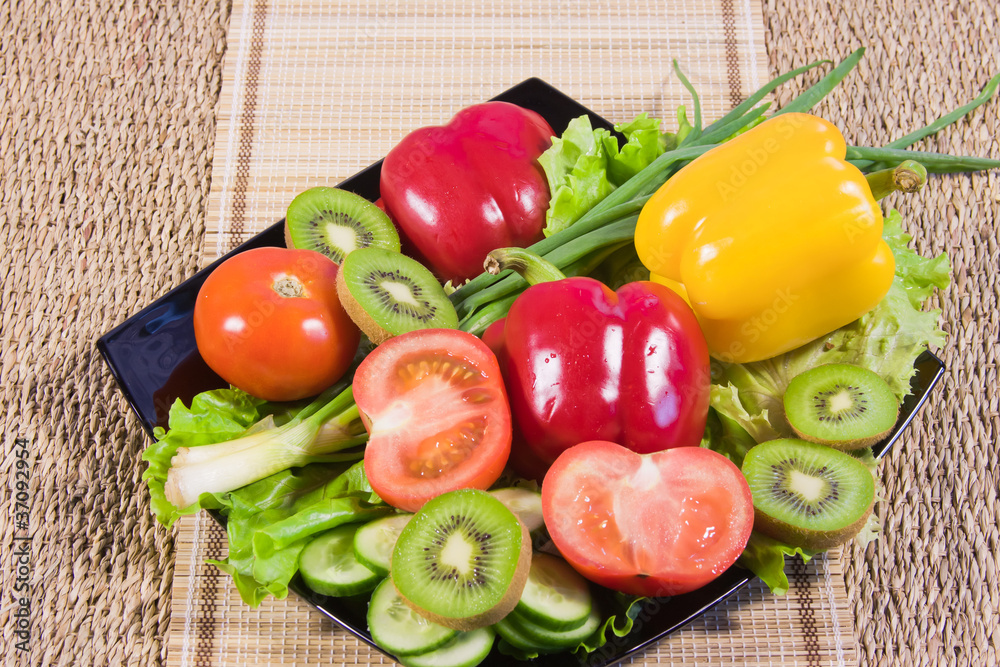 Varicoloured fruit and vegetables lie on a dish Varicoloured fruit and vegetables lie on a dish