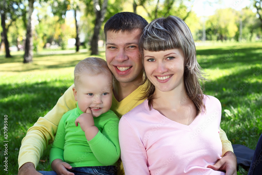 Young family with a child in summer park