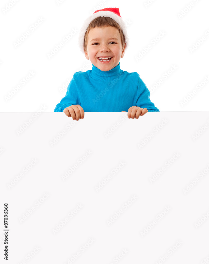 Smiling boy in Santa hat with empty banner Smiling boy in Santa hat with empty banner