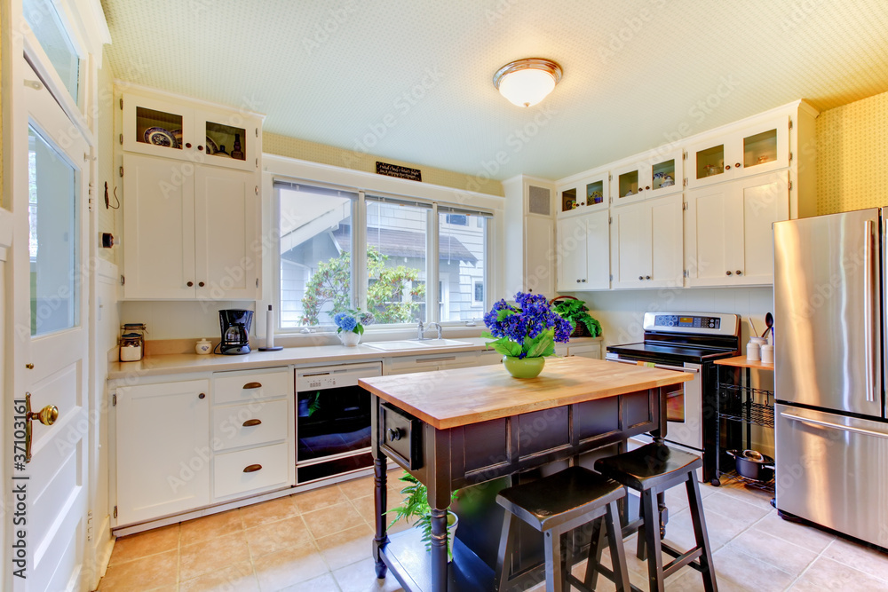 White antique remodeled kitchen with black island. White antique remodeled kitchen with black island.