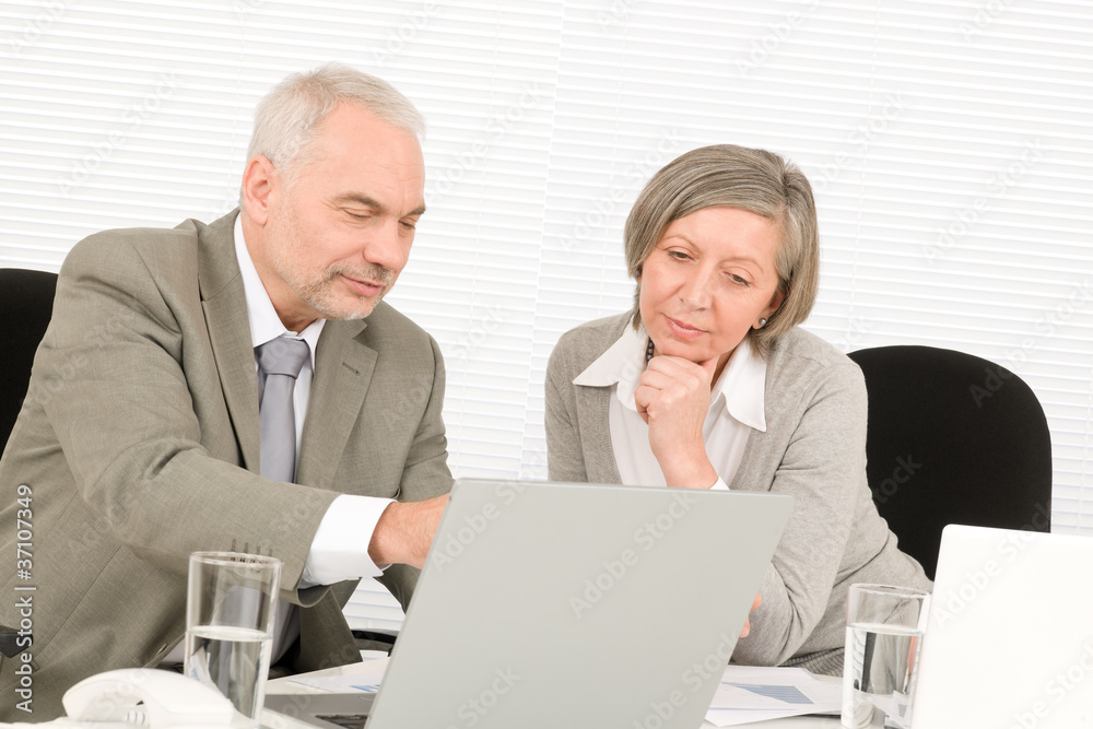 Senior businesspeople looking computer in office Senior businesspeople looking computer in office