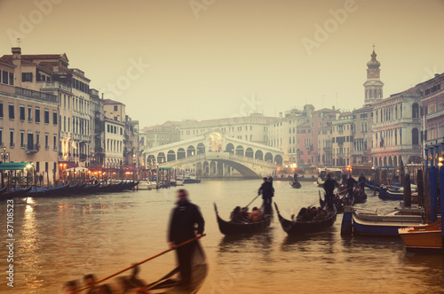 Rialto Bridge and gondolas at a foggy autumn evening in Venice.