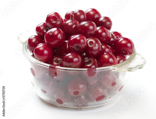 Bowl with ripe cherries. Isolated on a white background.