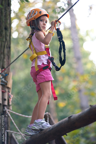 Young Girl climbing trees in Dolomites, Italy.