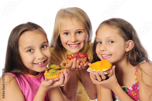 Kids eating cake with cream and fruits