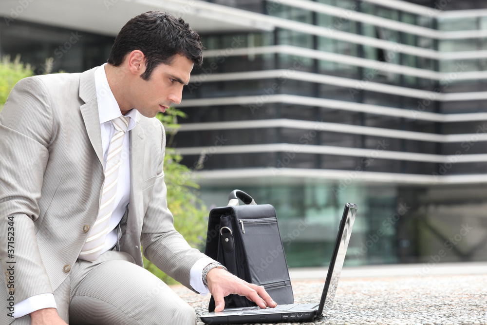 Man using a laptop outside Man using a laptop outside