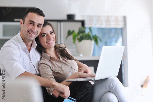 joyful couple relax and work on laptop computer at modern home