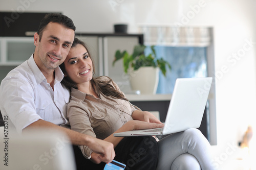 joyful couple relax and work on laptop computer at modern home