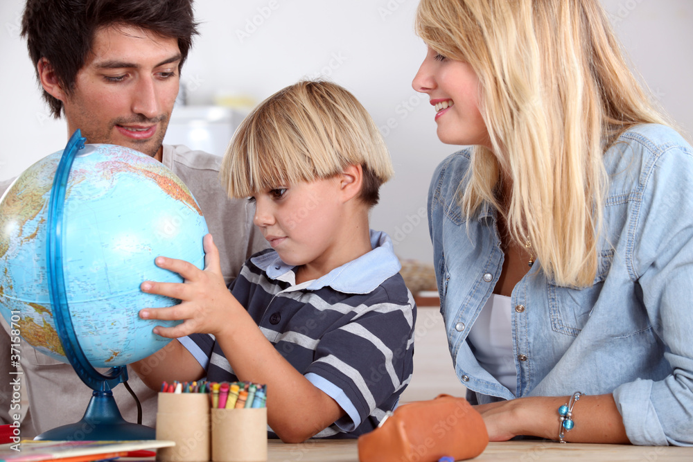 Fototapeta premium happy family looking terrestrial globe