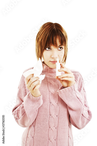 Young woman injecting drops into the nose