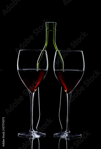 Pair of glasses of red wine with bottle
