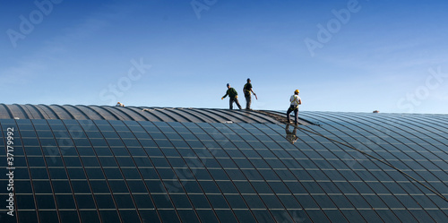 Operai che installano pannelli solari sul tetto photo