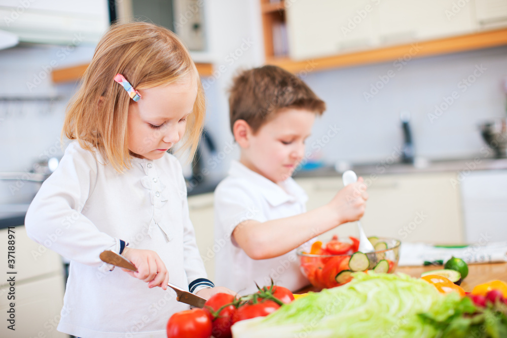 Two little kids making salad