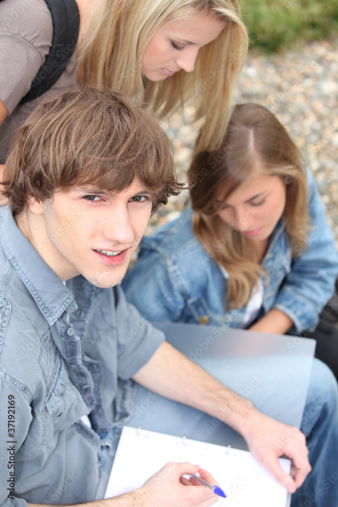 Young students outside with coursework Young students outside with coursework