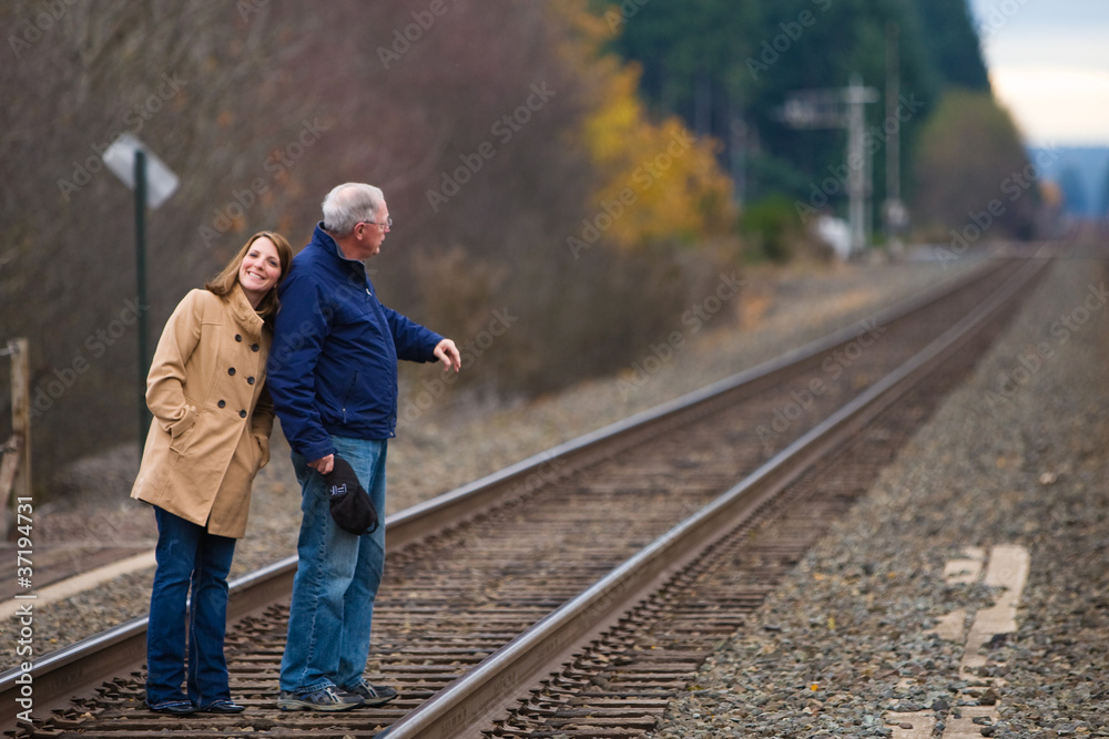Young woman and old man on train tracks