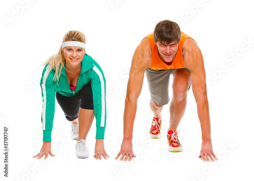 Healthy young man and fit female in start position ready for run © Alliance