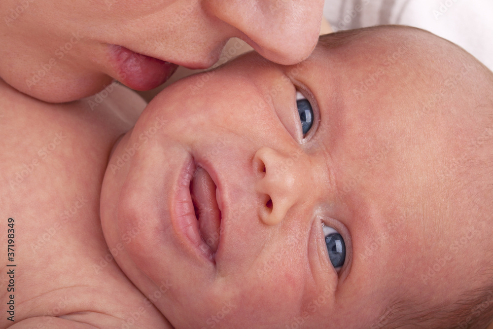 mother kissing her newborn daughter to calm her down. mother kissing her newborn daughter to calm her down.