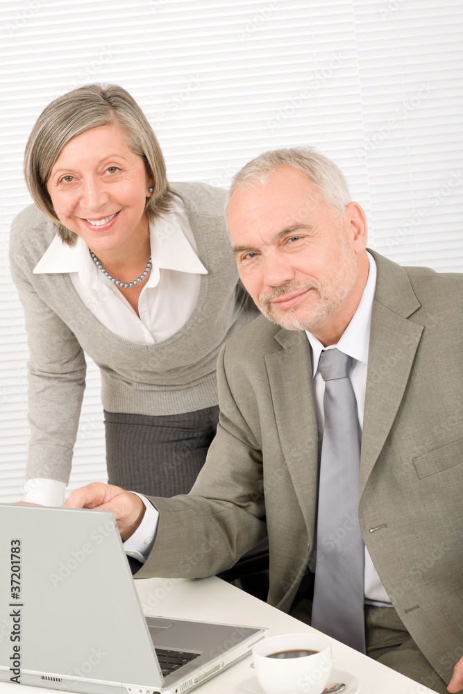 Senior businesspeople in office work on computer Senior businesspeople in office work on computer