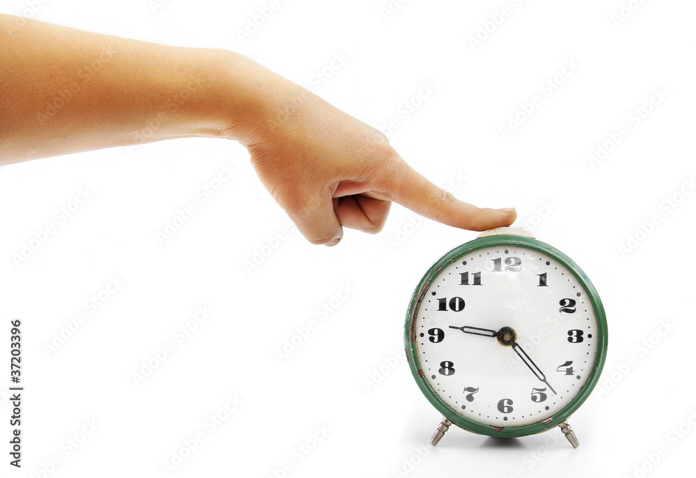 The female hand presses on the button of an old alarm clock The female hand presses on the button of an old alarm clock