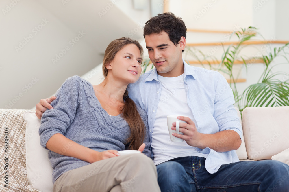 Couple watching TV while drinking coffee Couple watching TV while drinking coffee