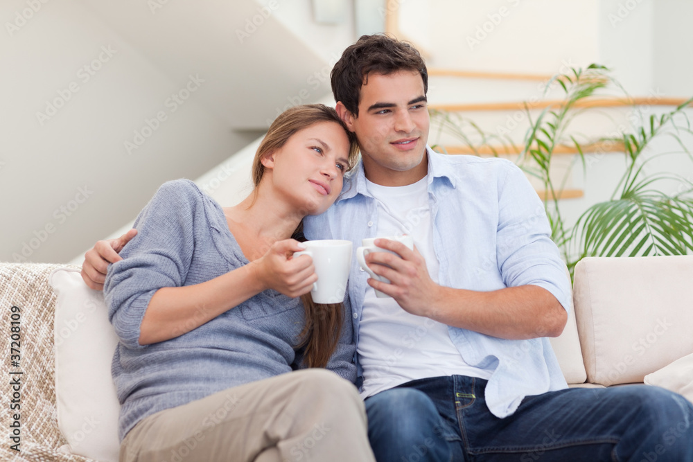 Lovely couple watching TV while drinking coffee Lovely couple watching TV while drinking coffee