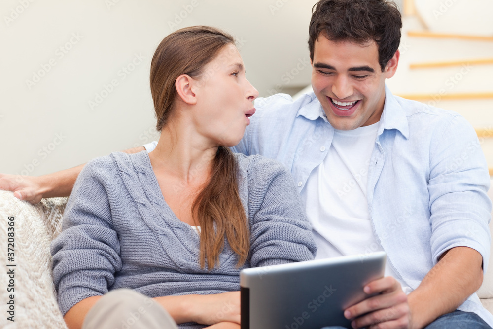 Laughing couple using a tablet computer Laughing couple using a tablet computer