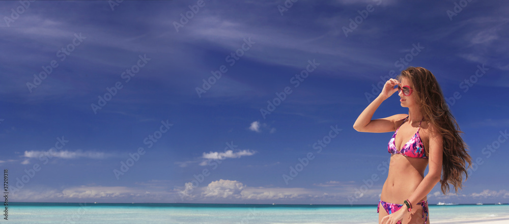 Naklejka premium young attractive woman in a bikini on tropical island