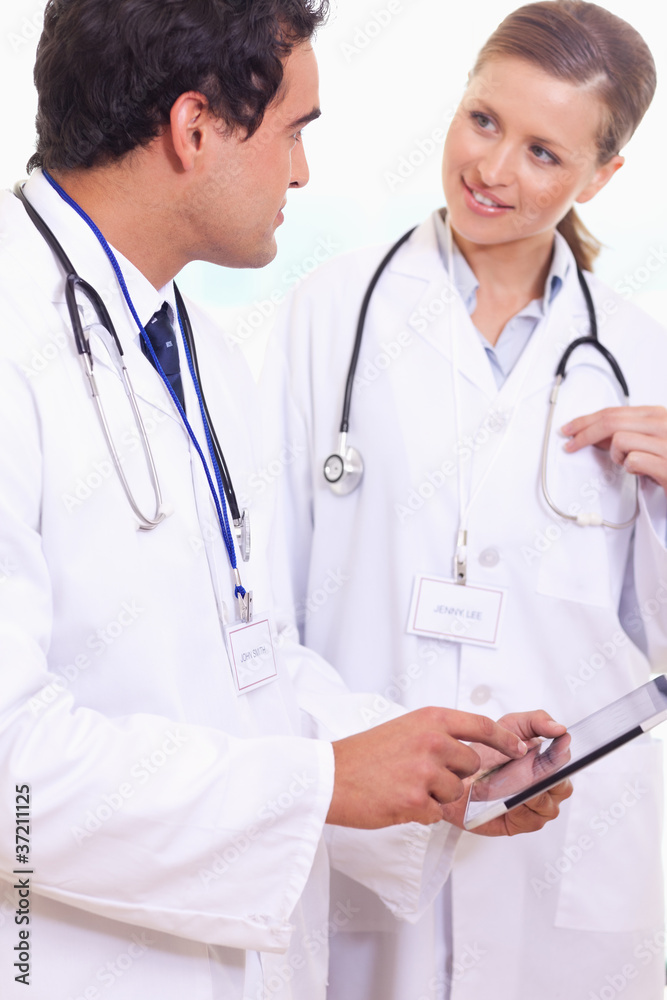Assistant doctors talking about what's on the tablet Assistant doctors talking about what's on the tablet