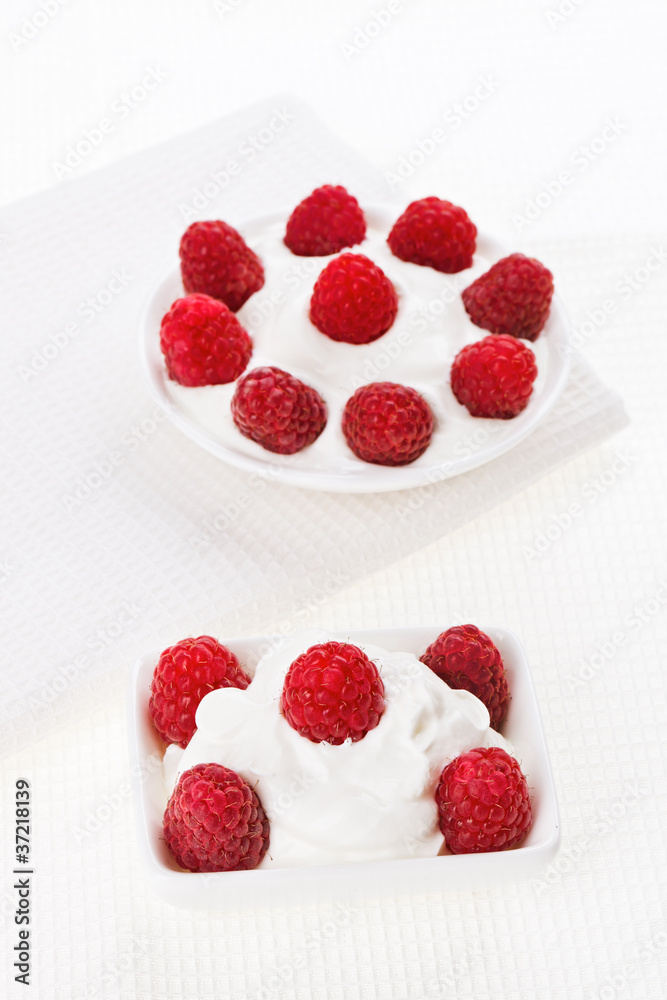 Still life with raspberry sour cream dessert on white linen tabl Still life with raspberry sour cream dessert on white linen tabl