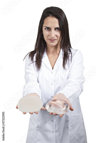 A vertical shot of a female doctor offering a silicone for breast Implant on white background