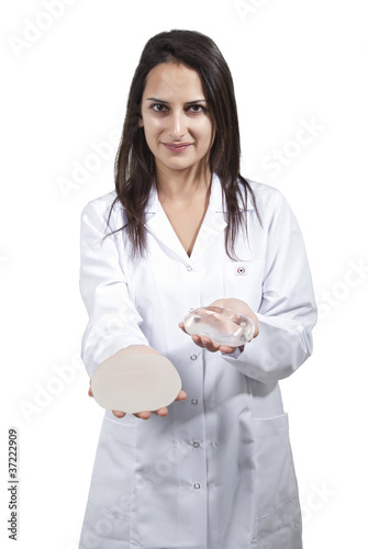 A vertical shot of a female doctor offering a silicone for breast Implant on white background