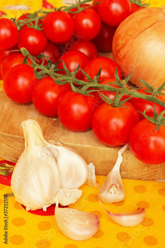 Garlic cloves with fresh cherry tomatoes and onion
