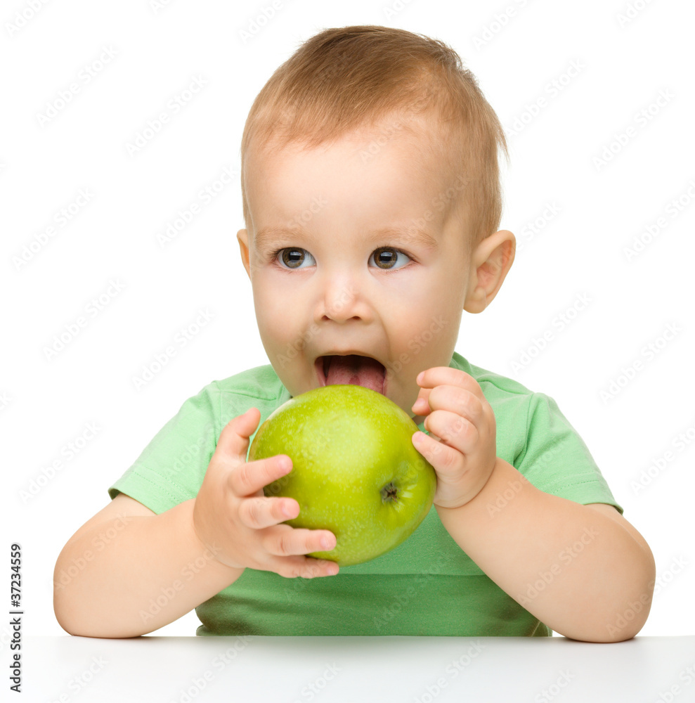 Little child is eating green apple Little child is eating green apple