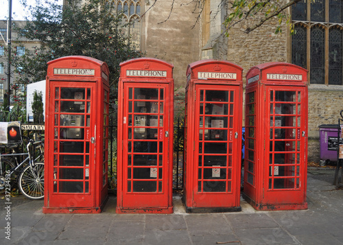 4 Traditional and iconic bright red telephone kiosks in Cambridge in the u.k.