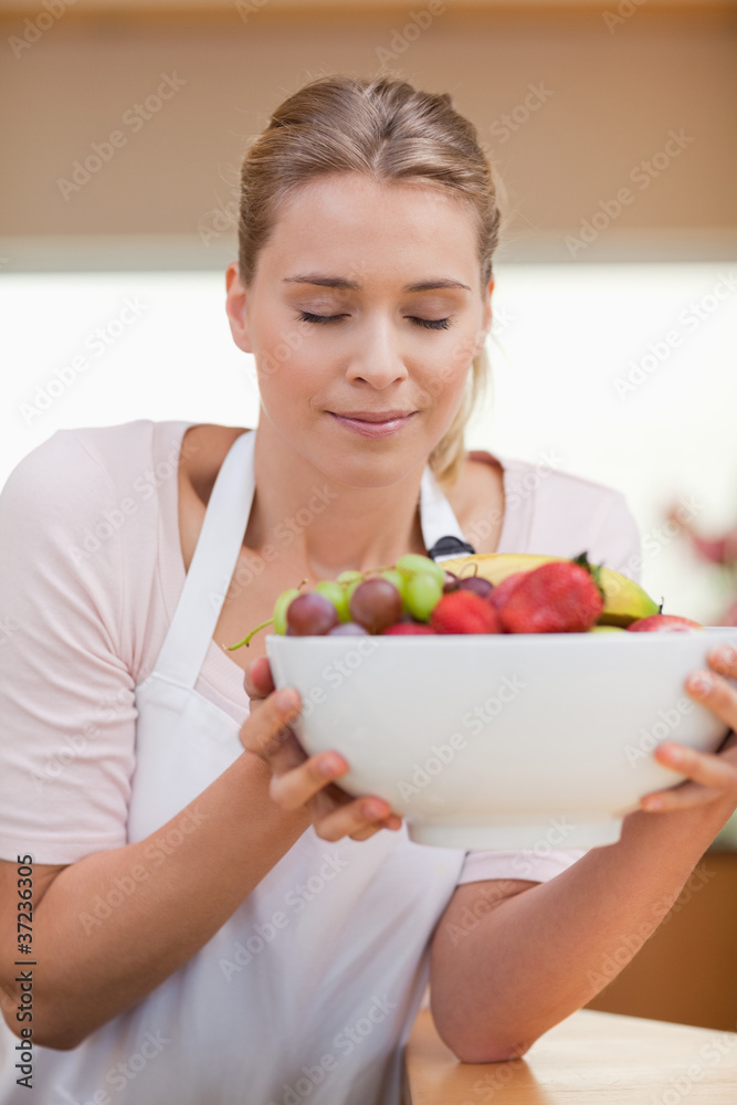 Portrait of a woman smelling a fruit basket Portrait of a woman smelling a fruit basket