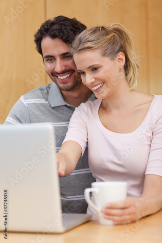 Portrait of a couple using a notebook while having tea