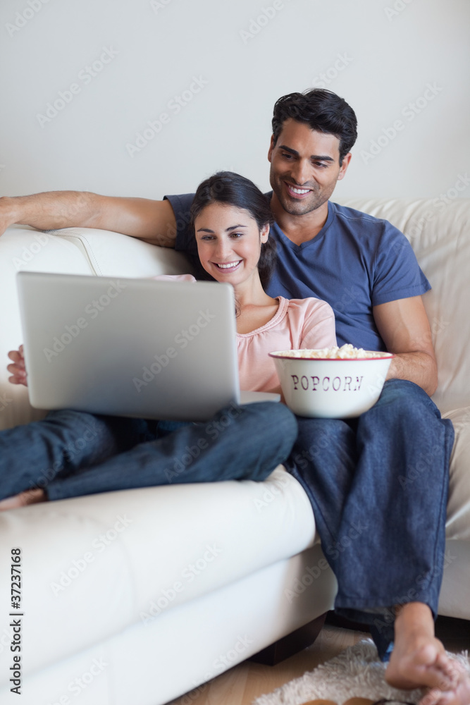 Portrait of a couple watching a movie while eating popcorn Portrait of a couple watching a movie while eating popcorn