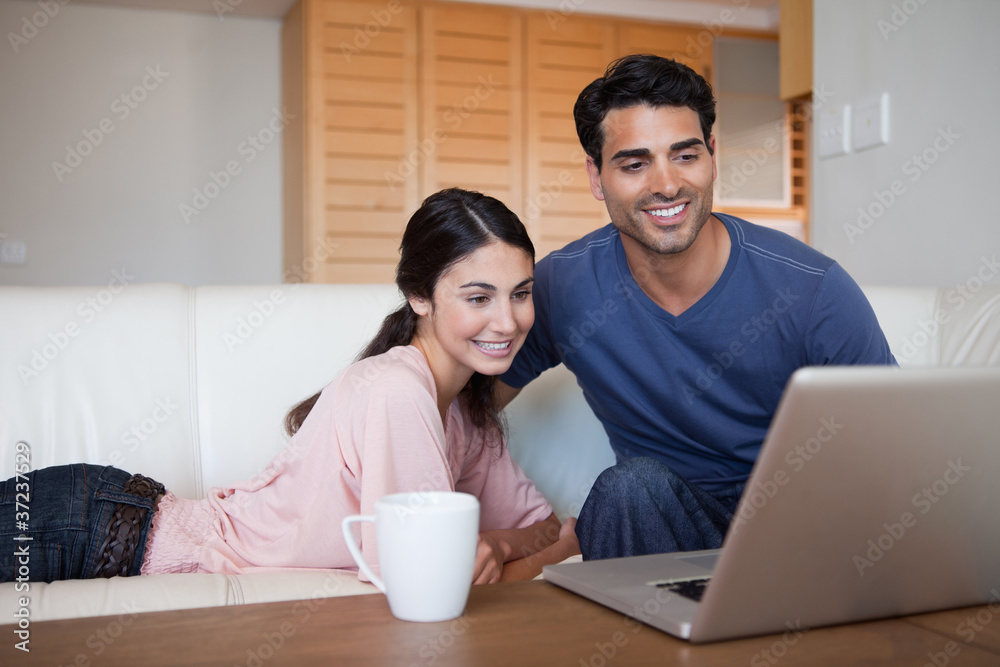 Young couple using a laptop while having a tea Young couple using a laptop while having a tea