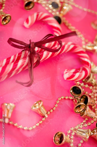 red and white Christmas candy canes on pink with bokeh overlay