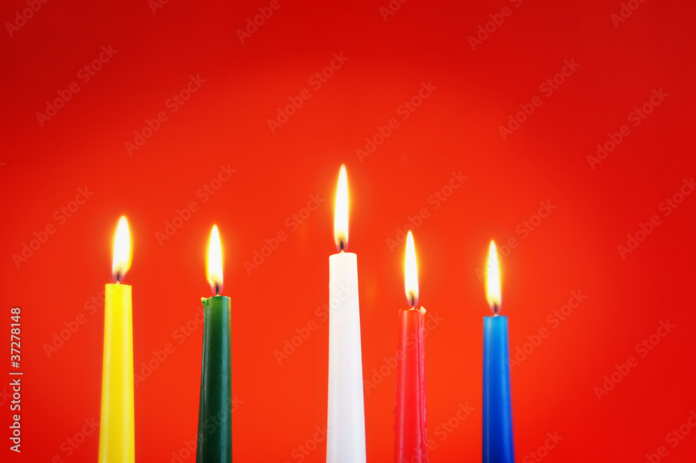 Five burning candles against the red background Five burning candles against the red background