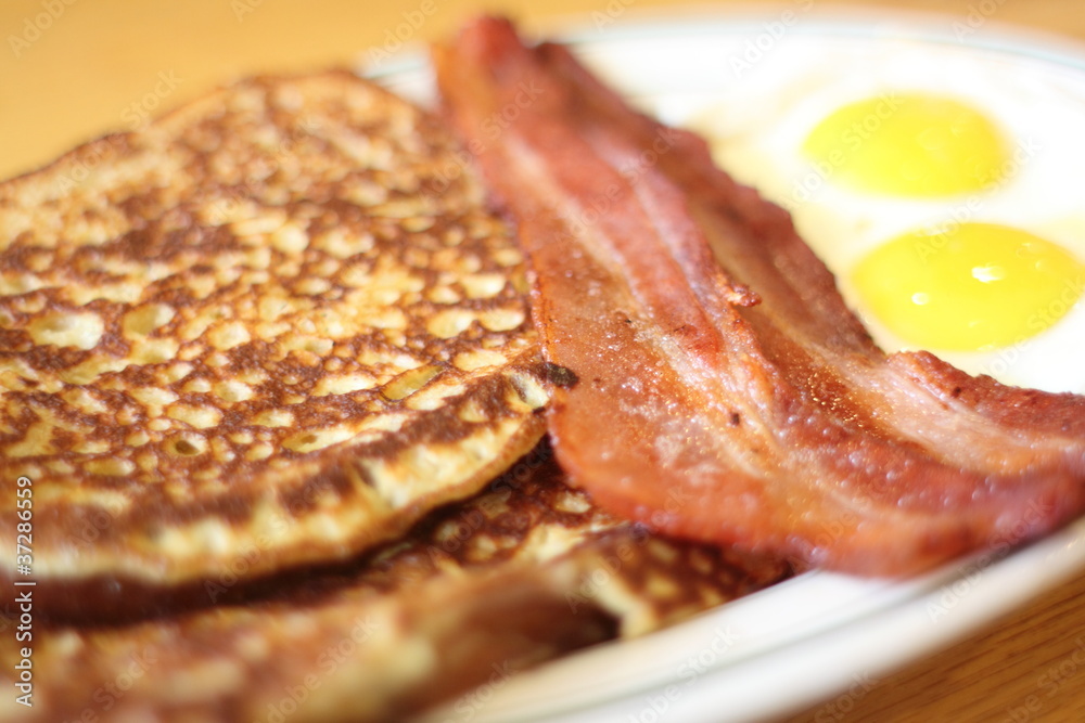 Delicious French toast with bacon and eggs for breakfast.