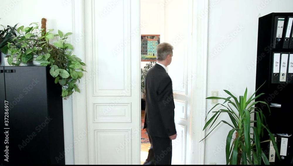 Ein Mann geht einem Bürozimmer durch die Türe
