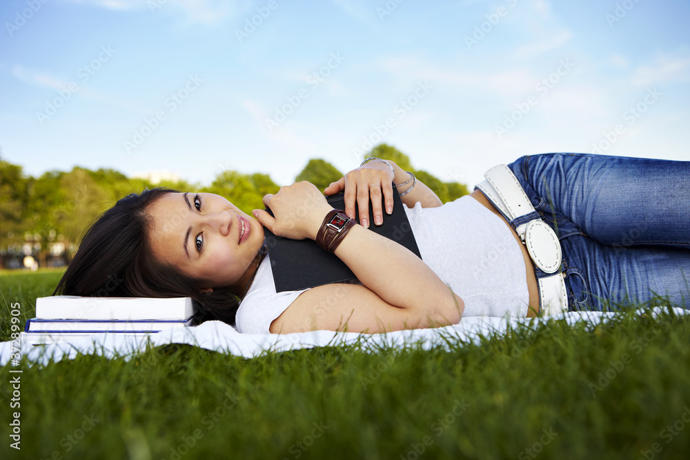 Mädchen verträumt,  mit Buch, liegt seitlich