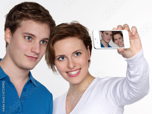 Young couple take a picture of themselves with smartphone photo