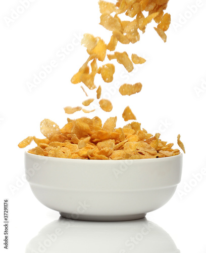 Photos Pouring cornflakes into a bowl, over white background