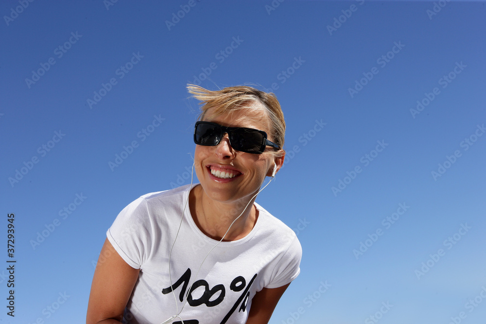 Naklejka premium Woman in sunglasses listening to music