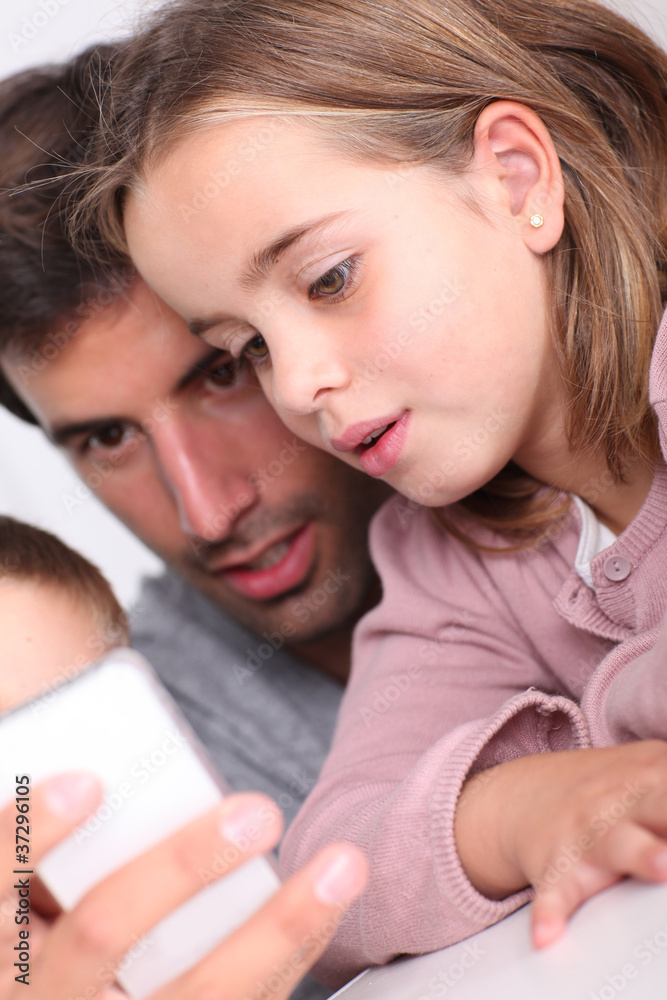 Father and children playing with smartphone