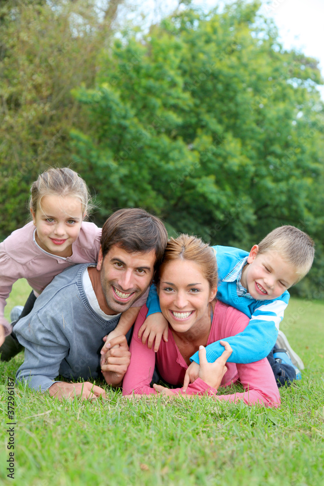 Portrait of happy family lying down in grass Portrait of happy family lying down in grass