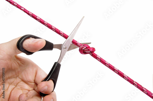 Scissors cutting a knot. A problem solving concept