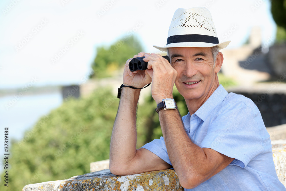 Obraz premium senior gentleman admiring view with binoculars